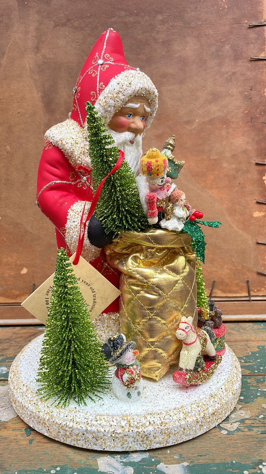 Postpox Red Santa with Gold & Silver Decoration & Crystals, Soft Gold Bag with Toys on Display | Ino Schaller