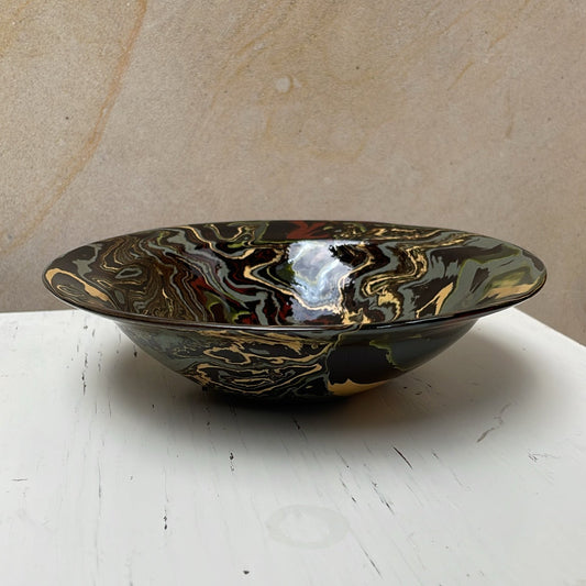 Decorative bowl with marbled design on a white surface