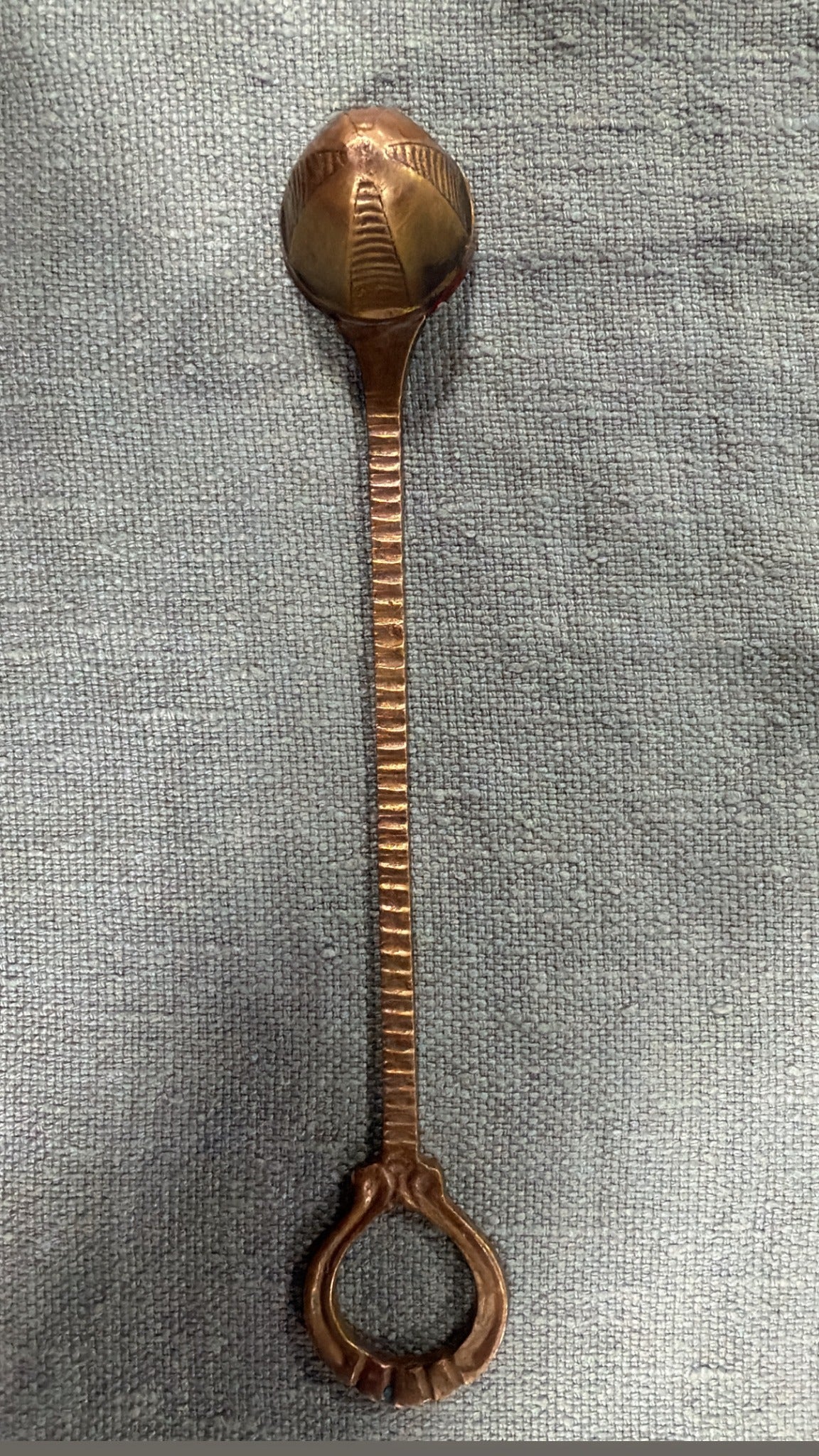Vintage brass candle snuffer with rounded patterned head, ridged stem and open loop handle, 22 cm long