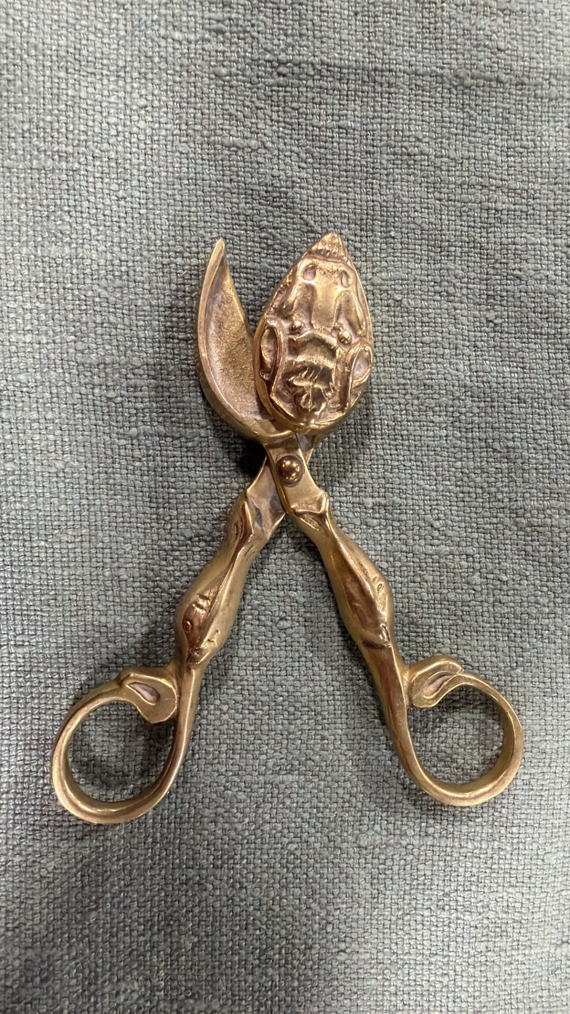 Vintage brass wick trimmer, 14 cm long, with sculptural handles, round finger loops and decorative relief on its curved wick-catching head