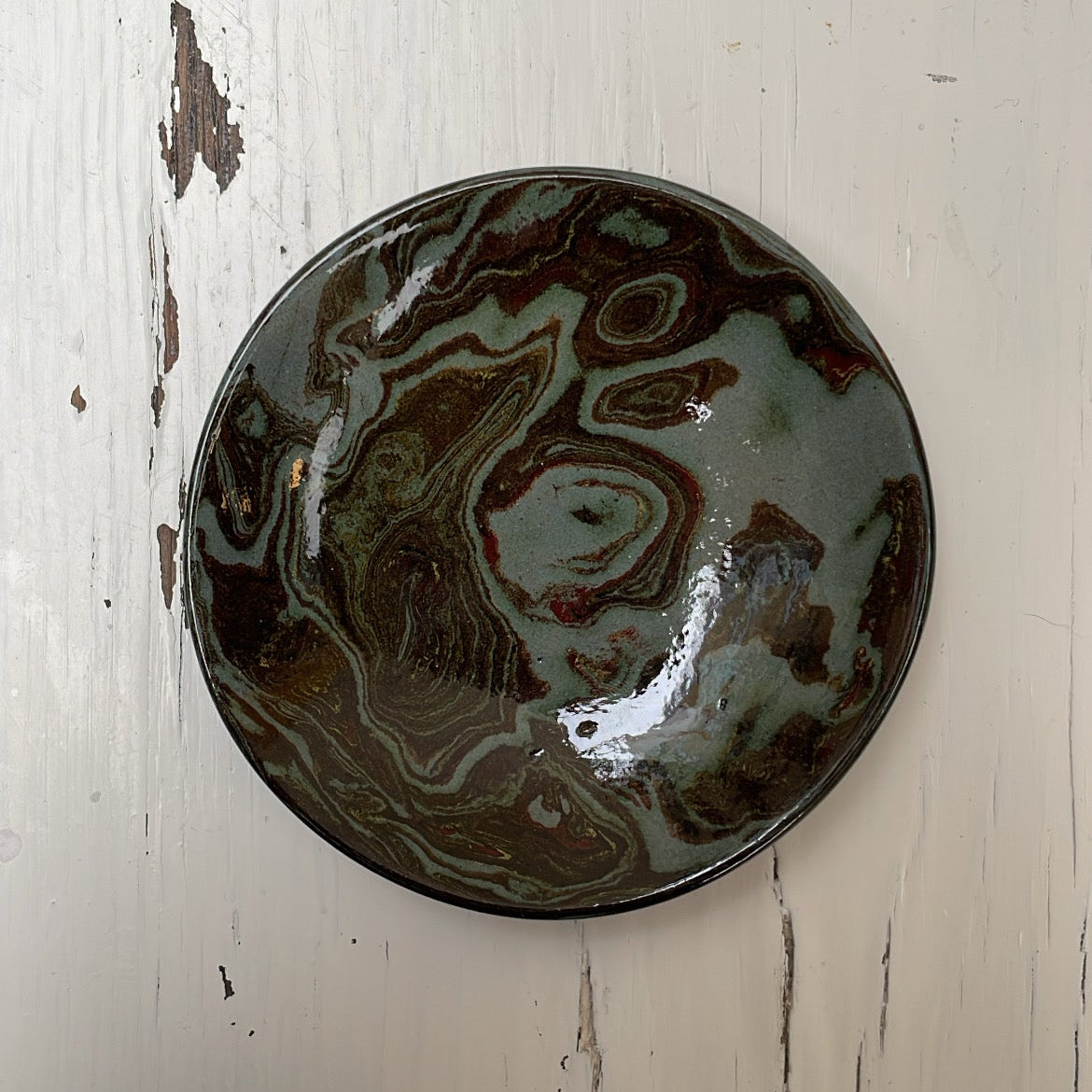 Ceramic plate with marbled design on a white wooden surface