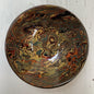 Decorative ceramic bowl with marbled design on a white wooden surface