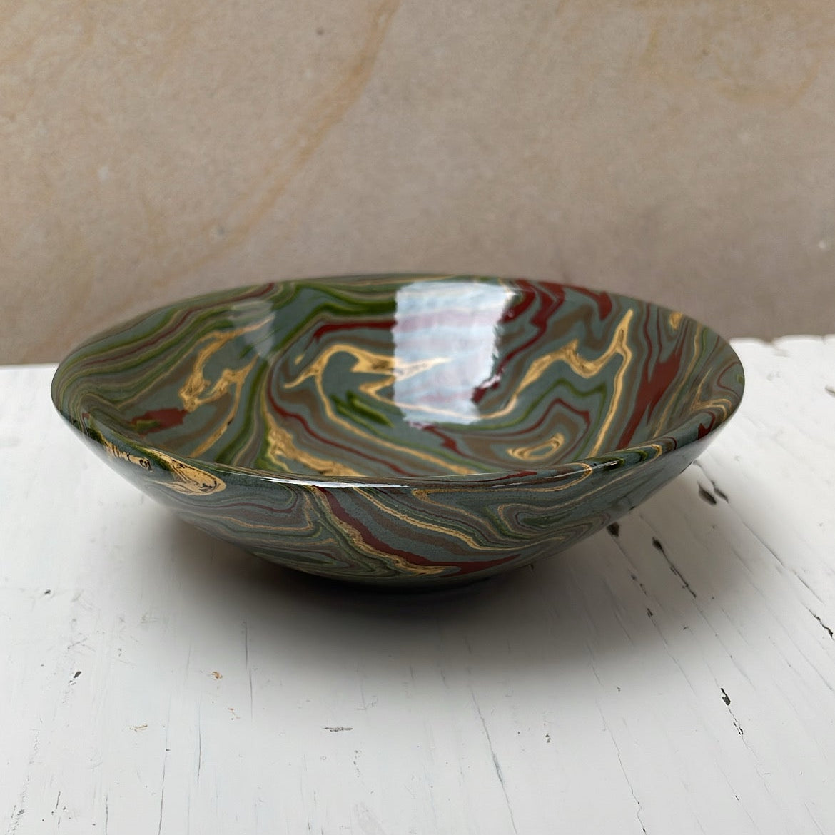 Decorative ceramic bowl with marbled design on a white surface
