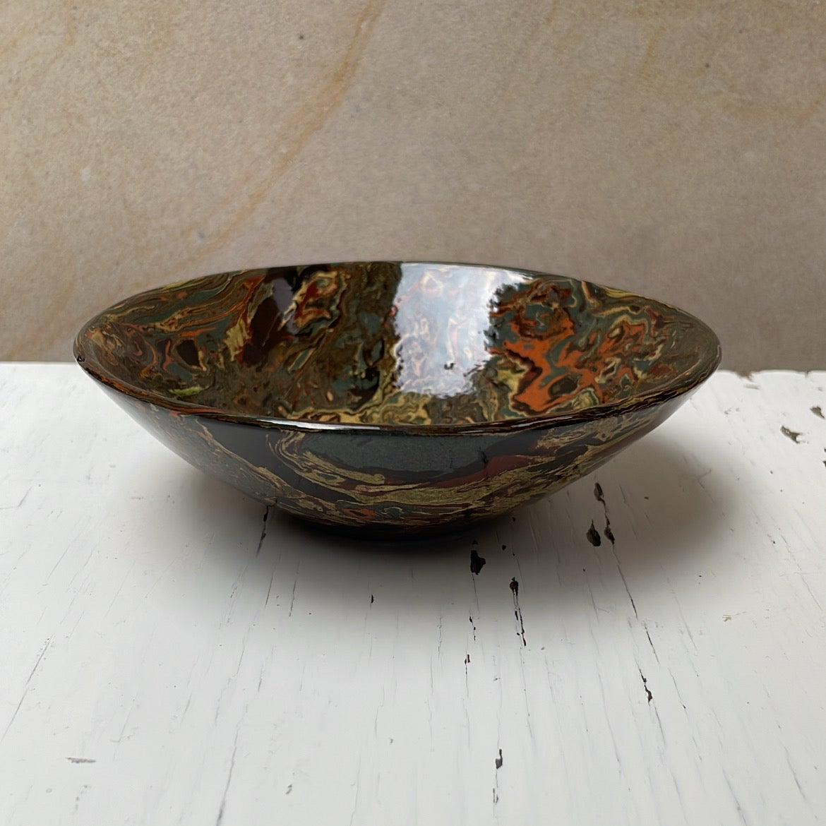 Decorative bowl with a speckled pattern on a white surface