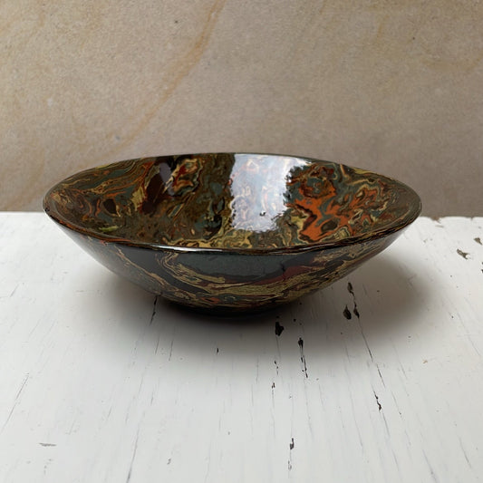 Decorative bowl with a speckled pattern on a white surface
