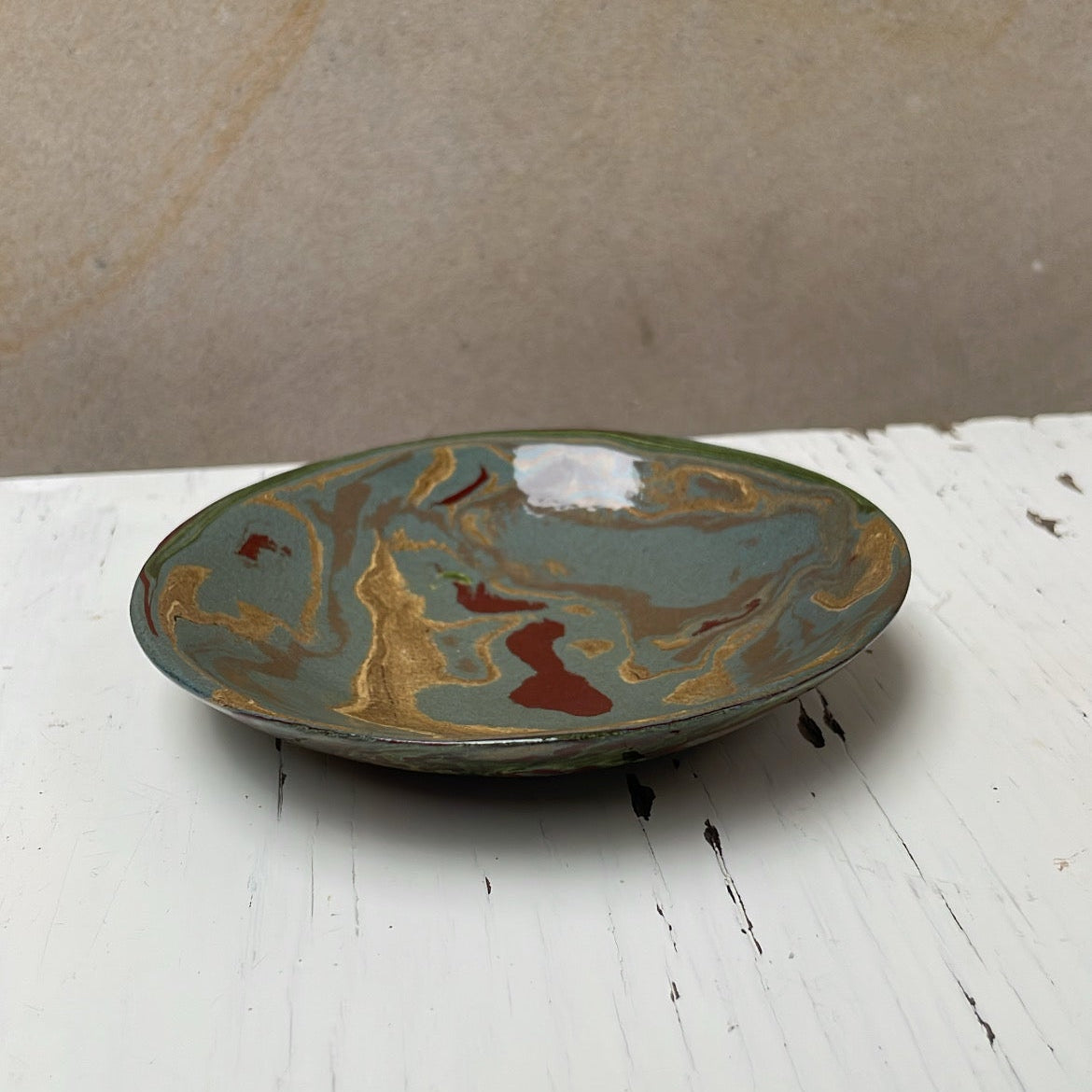 Ceramic plate with marbled design on a white surface