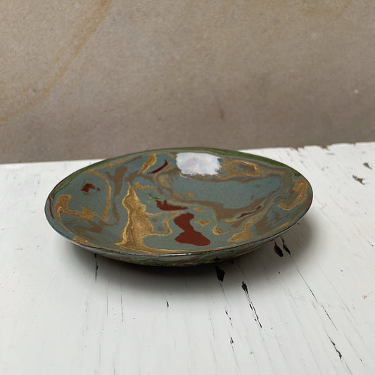 Ceramic plate with marbled design on a white surface