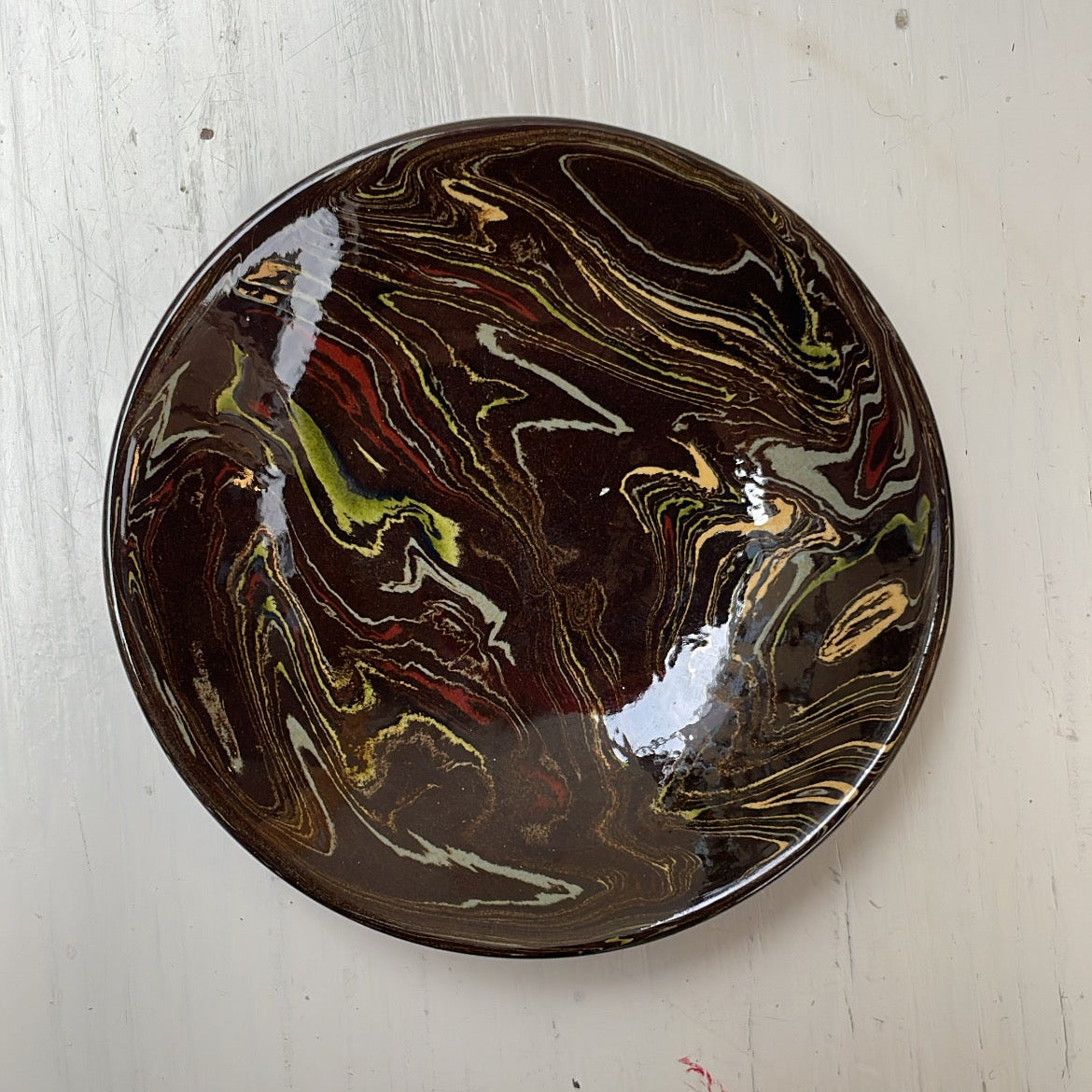Round ceramic plate with marbled design on a white surface