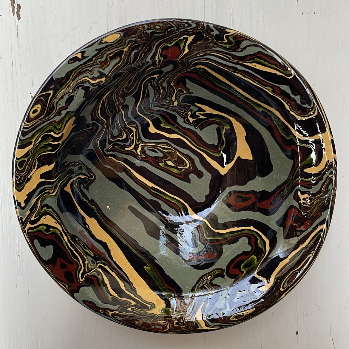 Marbled ceramic bowl on a white wooden surface