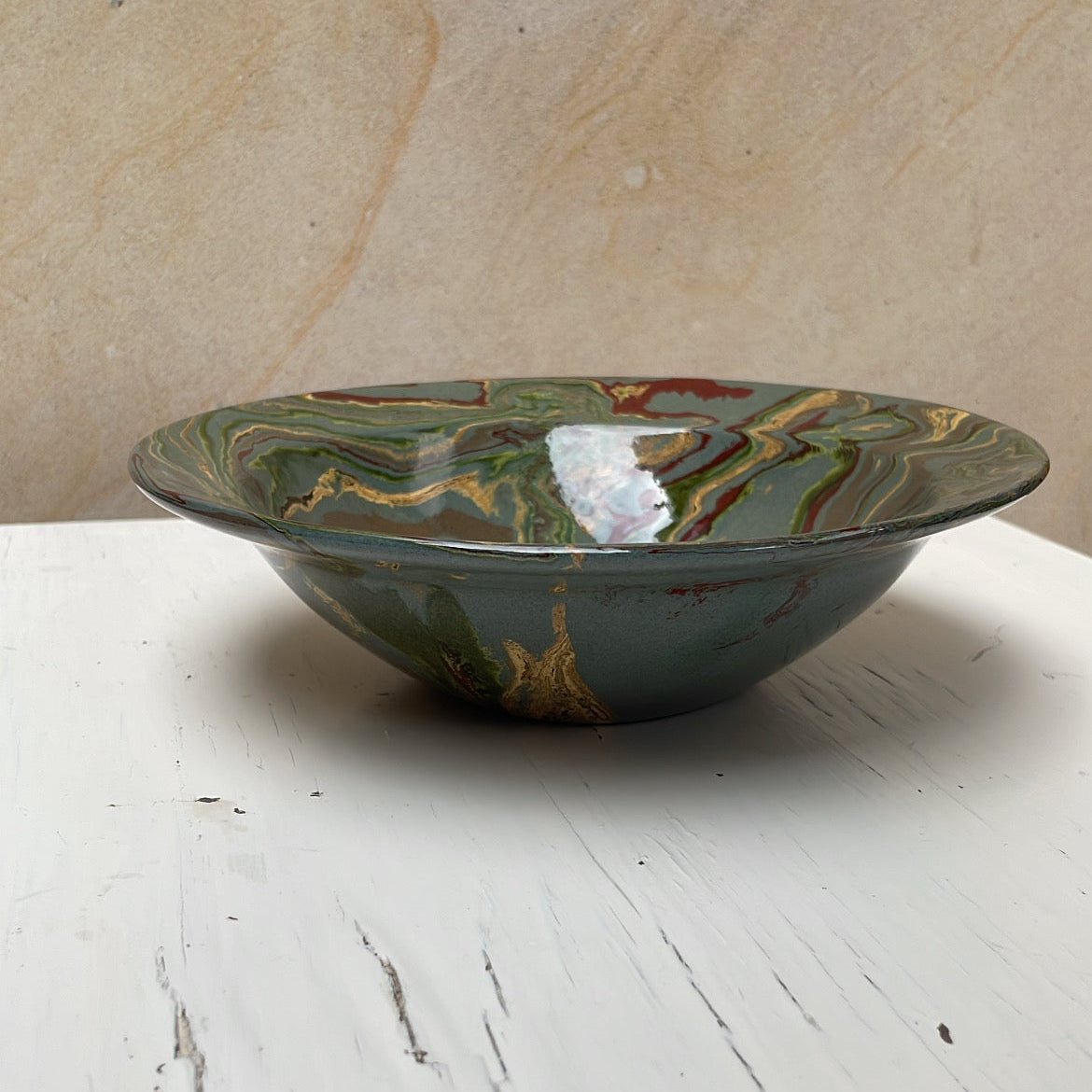 Decorative ceramic bowl with marbled design on a white surface