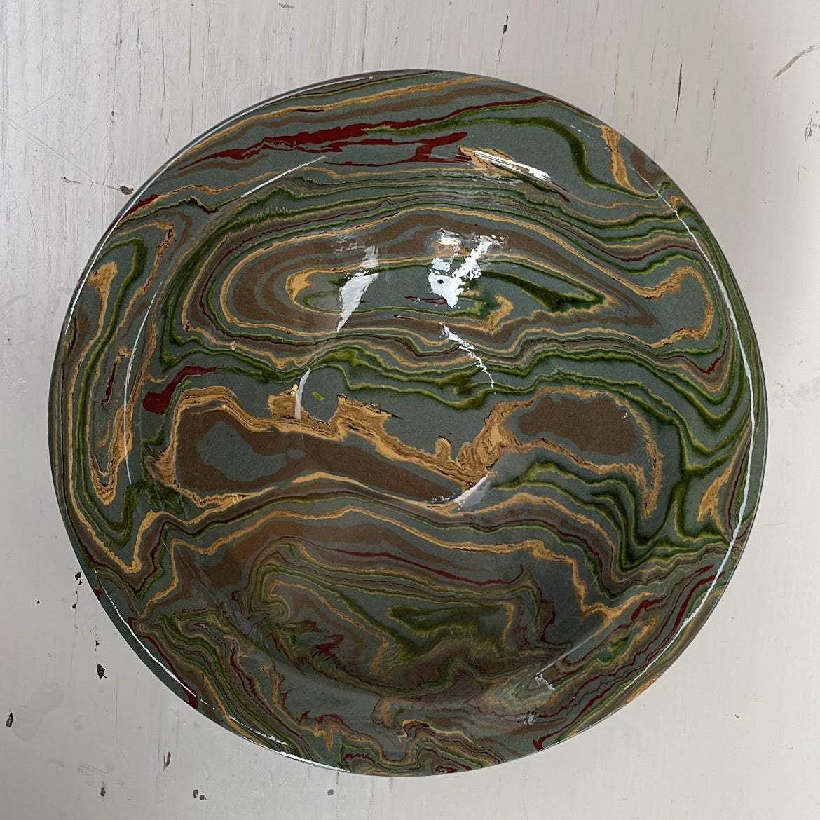 Marbled ceramic bowl on a white wooden surface