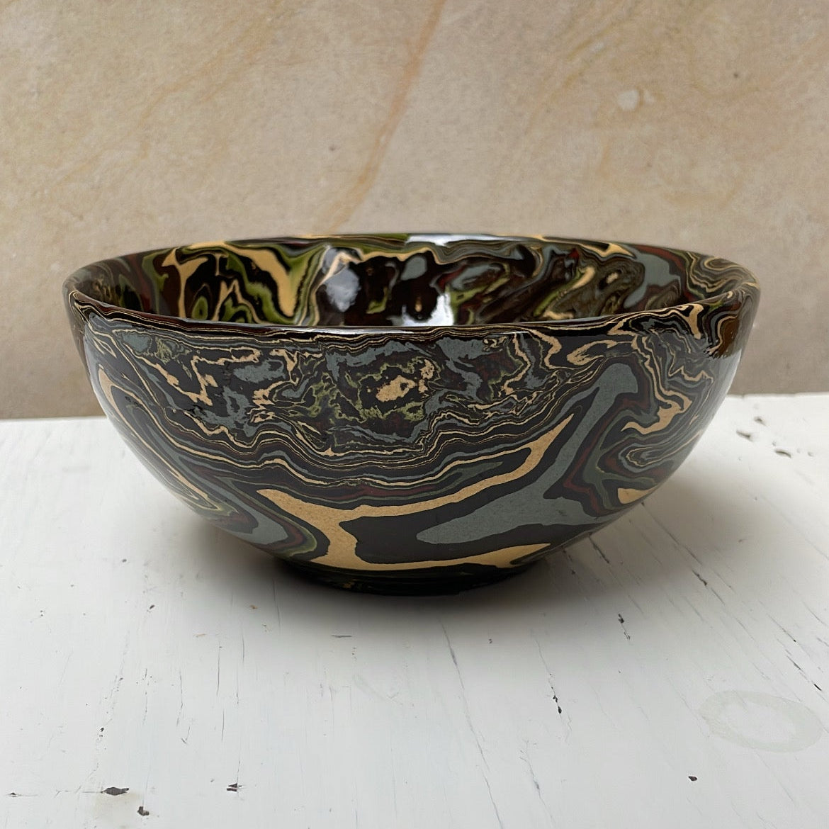 Decorative ceramic bowl with marbled design on a white surface