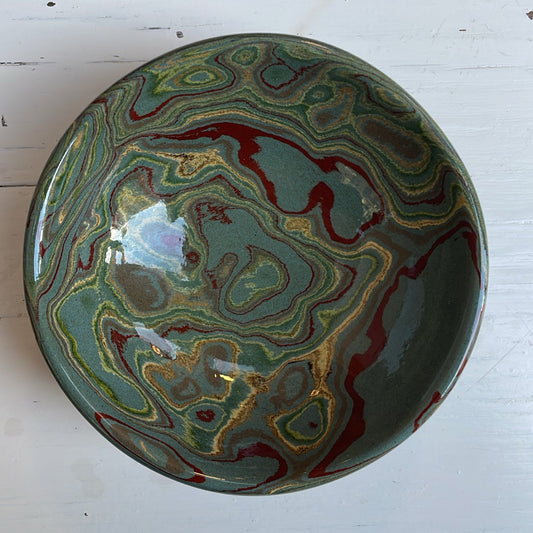 Decorative ceramic bowl with marbled design on a white surface
