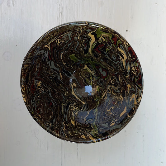 Round ceramic dish with marbled design on a white background