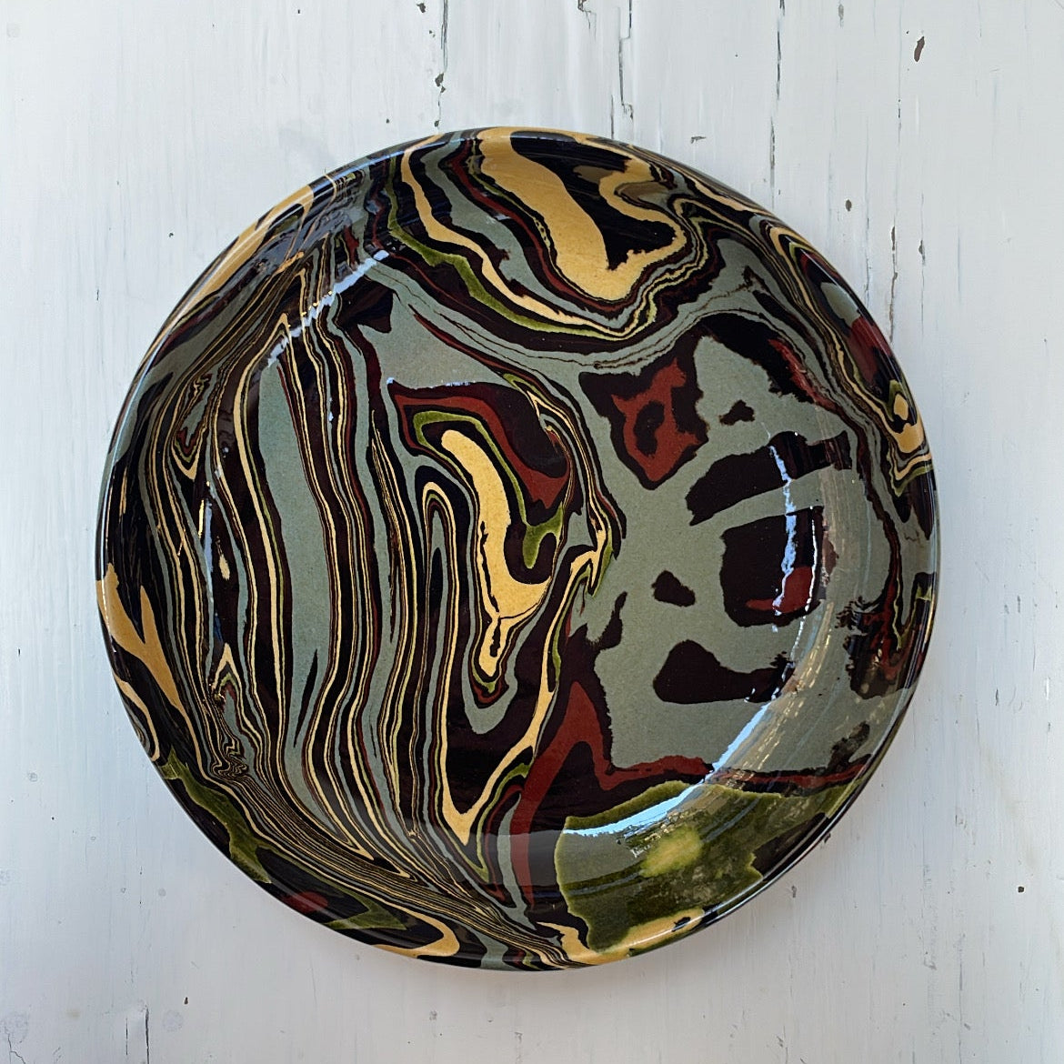 Marbled ceramic bowl on a white wooden surface