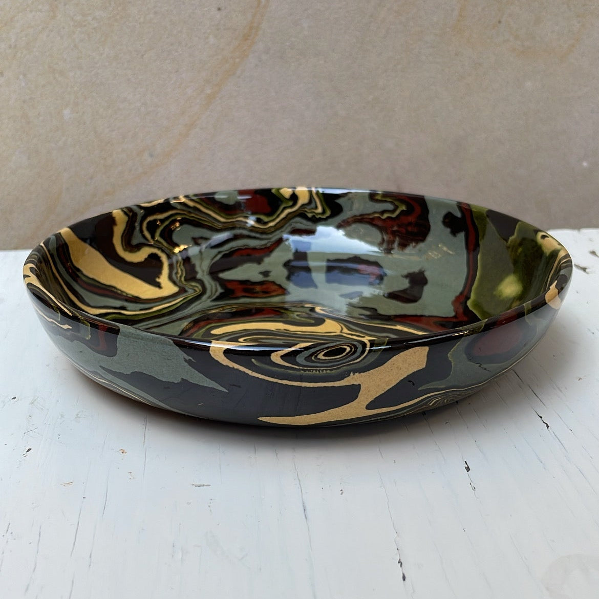 Decorative ceramic bowl with marbled design on a white surface