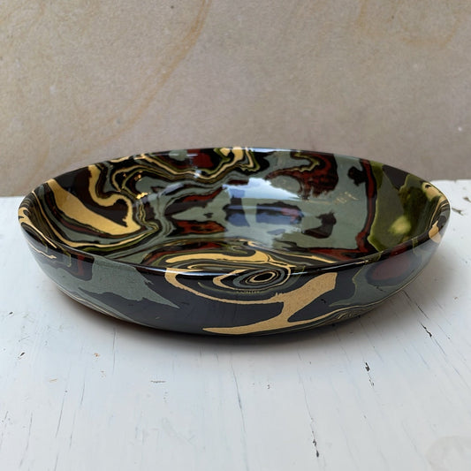Decorative ceramic bowl with marbled design on a white surface