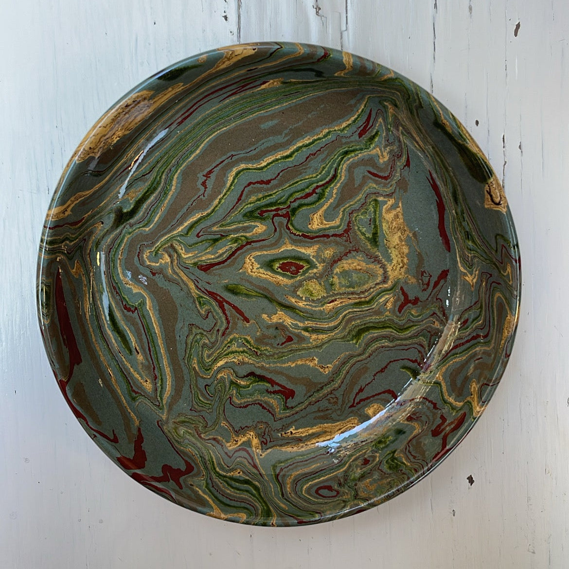 Marbled ceramic plate on a white wooden surface