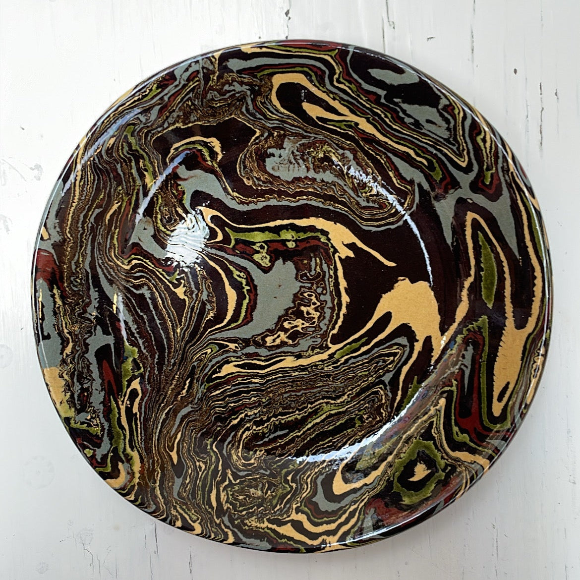 Round decorative item with marbled design on a white background