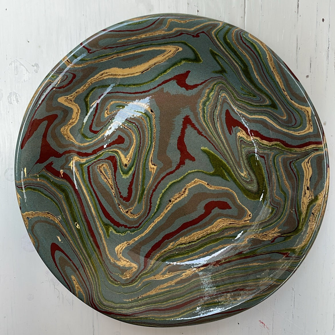 Marbled ceramic plate on a white wooden surface