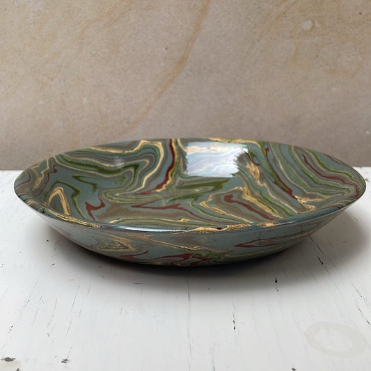 Decorative ceramic bowl with marbled design on a white surface