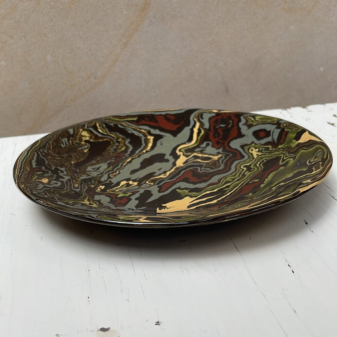 Decorative plate with marbled design on a white surface