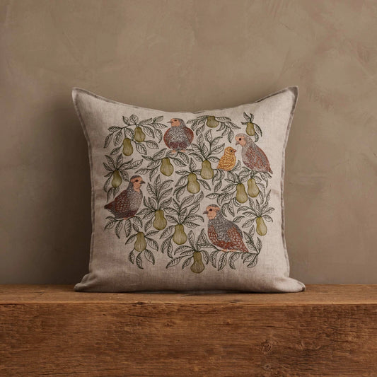 Coral & Tusk Partridge in a Pear Tree pillow styled on a wooden surface