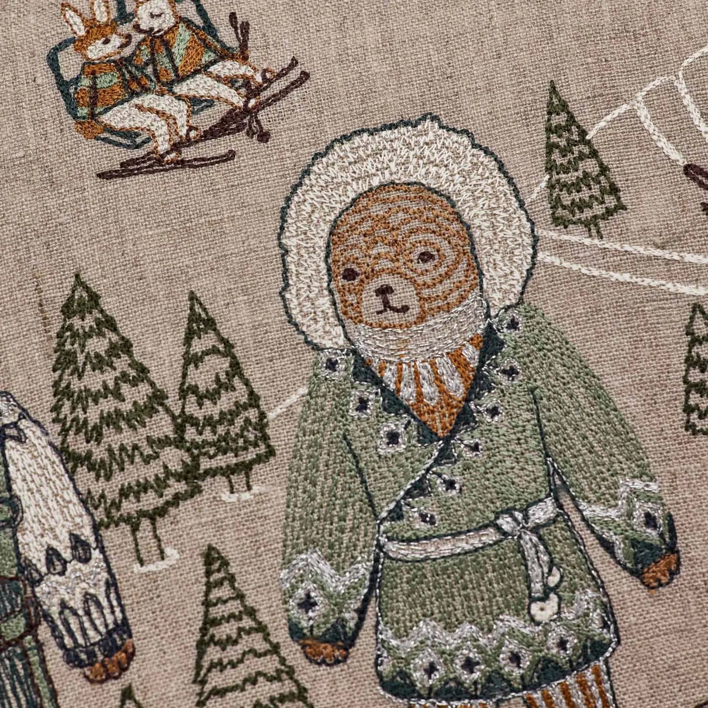 Bear in blue and silver coat embroidery detail on the Ski Slope pillow