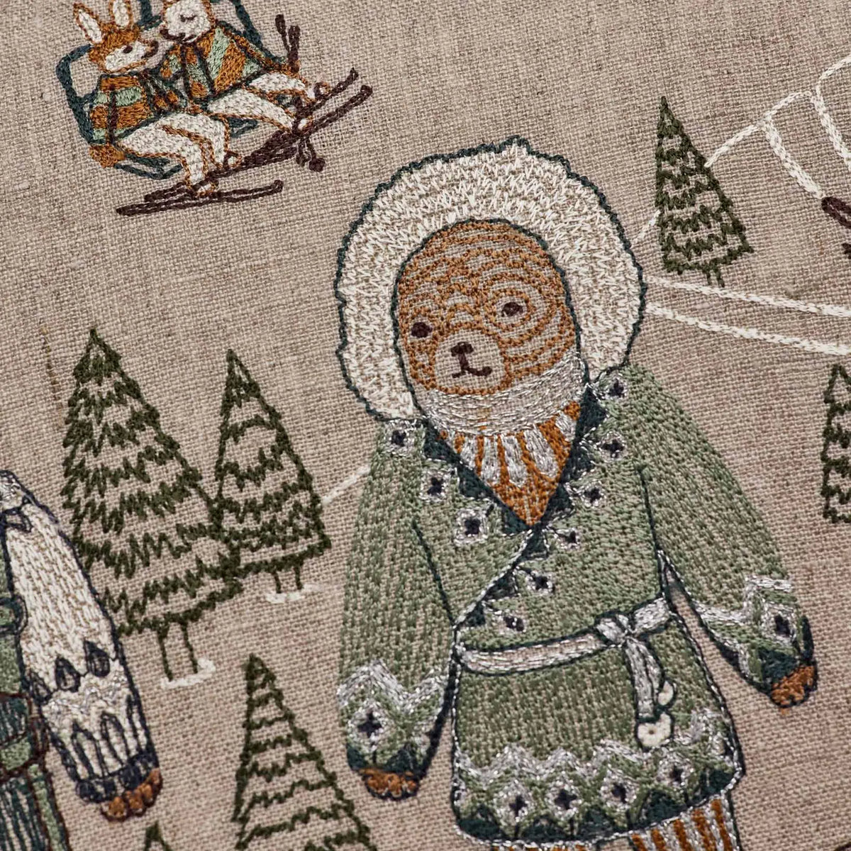 Bear in blue and silver coat embroidery detail on the Ski Slope pillow