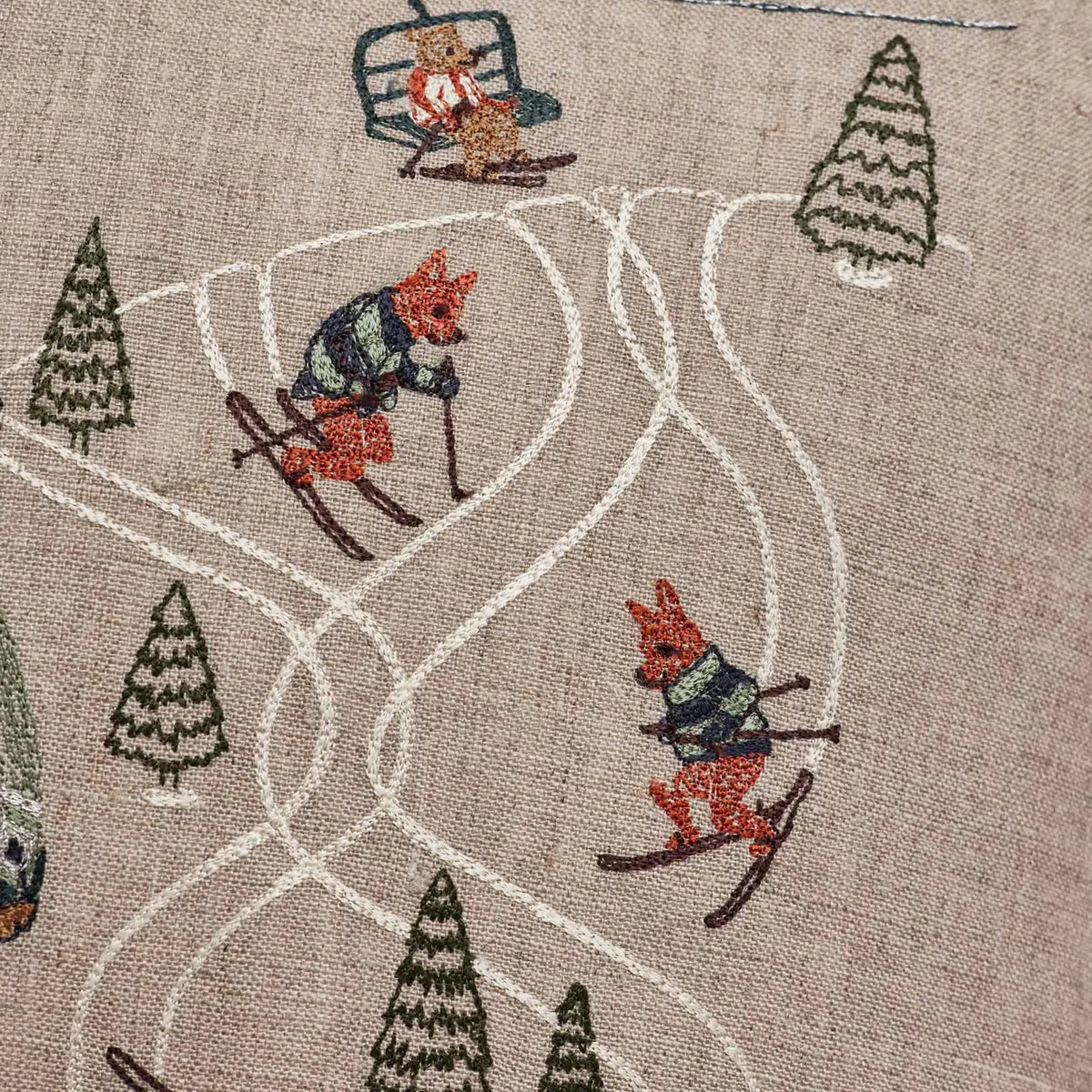 Downhill skiers embroidery detail on the Coral & Tusk Ski Slope pillow