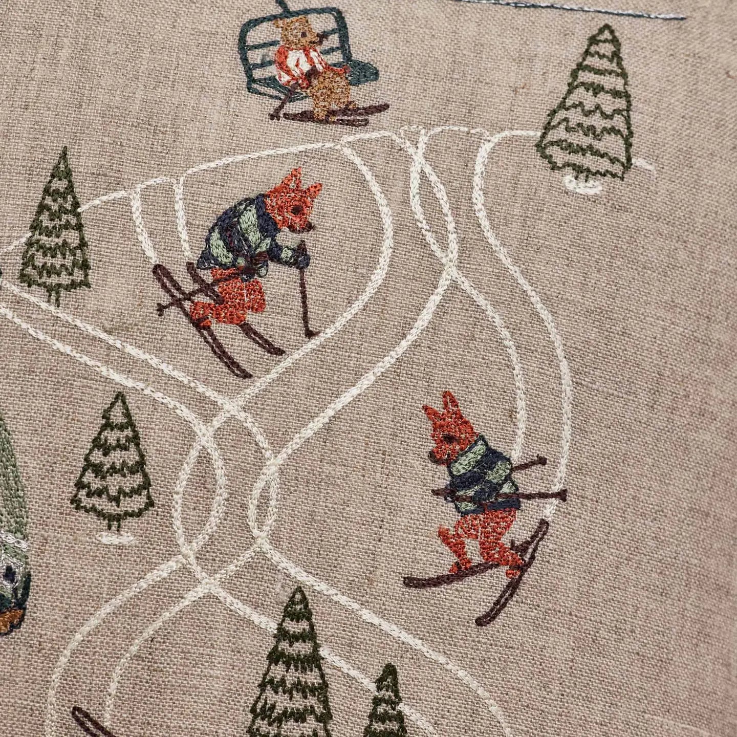 Downhill skiers embroidery detail on the Coral & Tusk Ski Slope pillow