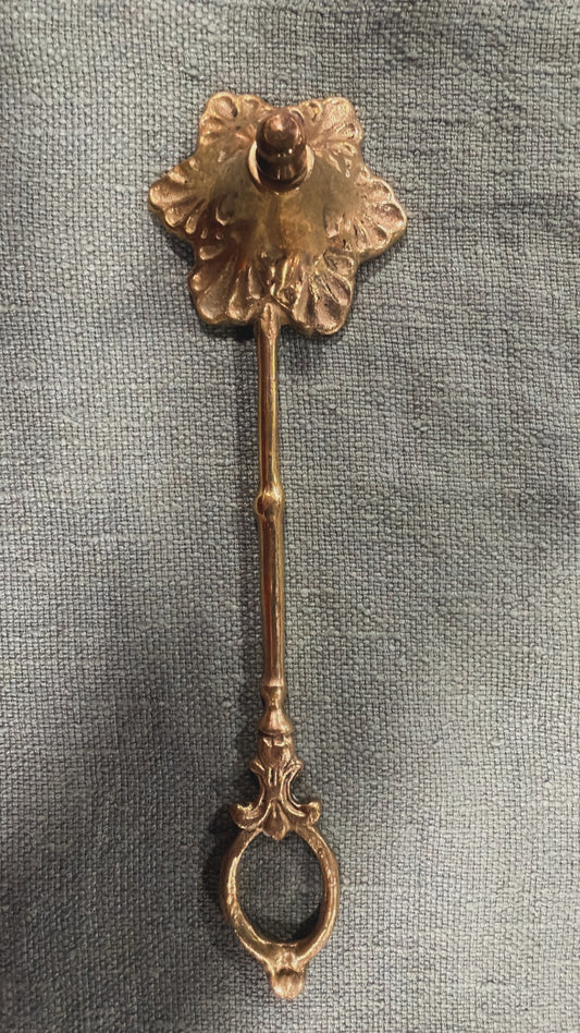 Vintage brass candle snuffer with scalloped foliate head and decorative loop handle, 24 cm long