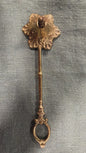 Vintage brass candle snuffer with scalloped foliate head and decorative loop handle, 24 cm long